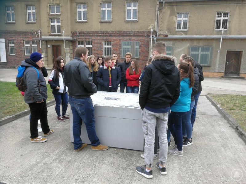 Historiker André Kistner (Mitte) erläuterte den Schülerinnen und Schülern am Modell zunächst den Aufbau des ehemaligen Stasi-Gefängnisses Hohenschönhausen, bevor er ihnen Zellen und Verhörräume im Inneren der Gebäude zeigte.