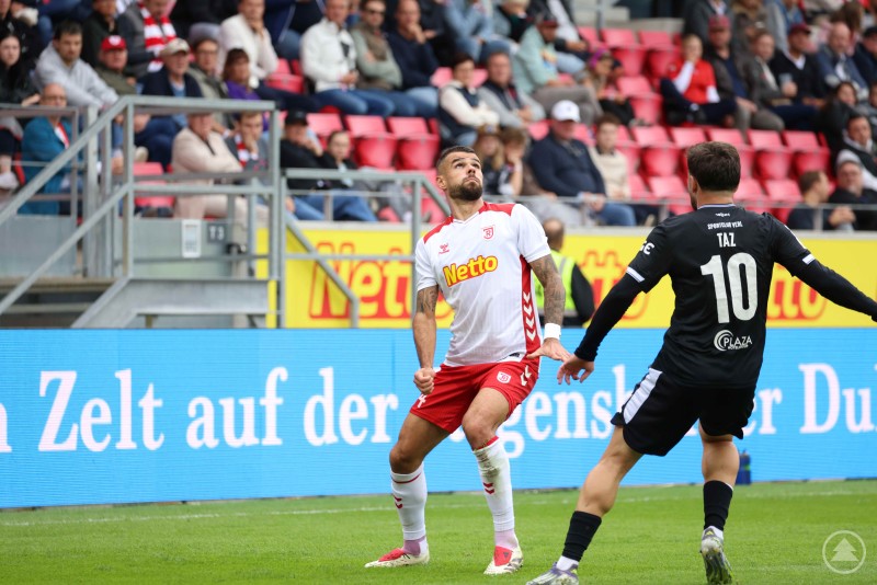 Zweikampfszene zwischen einem Spieler des SSV Jahn Regensburg und einem Spieler des SC Verl (Nummer 10, Taz).