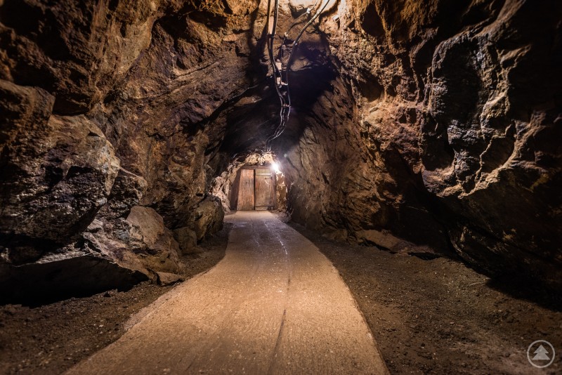 Ein beleuchteter Stollenweg f&uuml;hrt durch einen felsigen Tunnel im Inneren des Silberbergs.