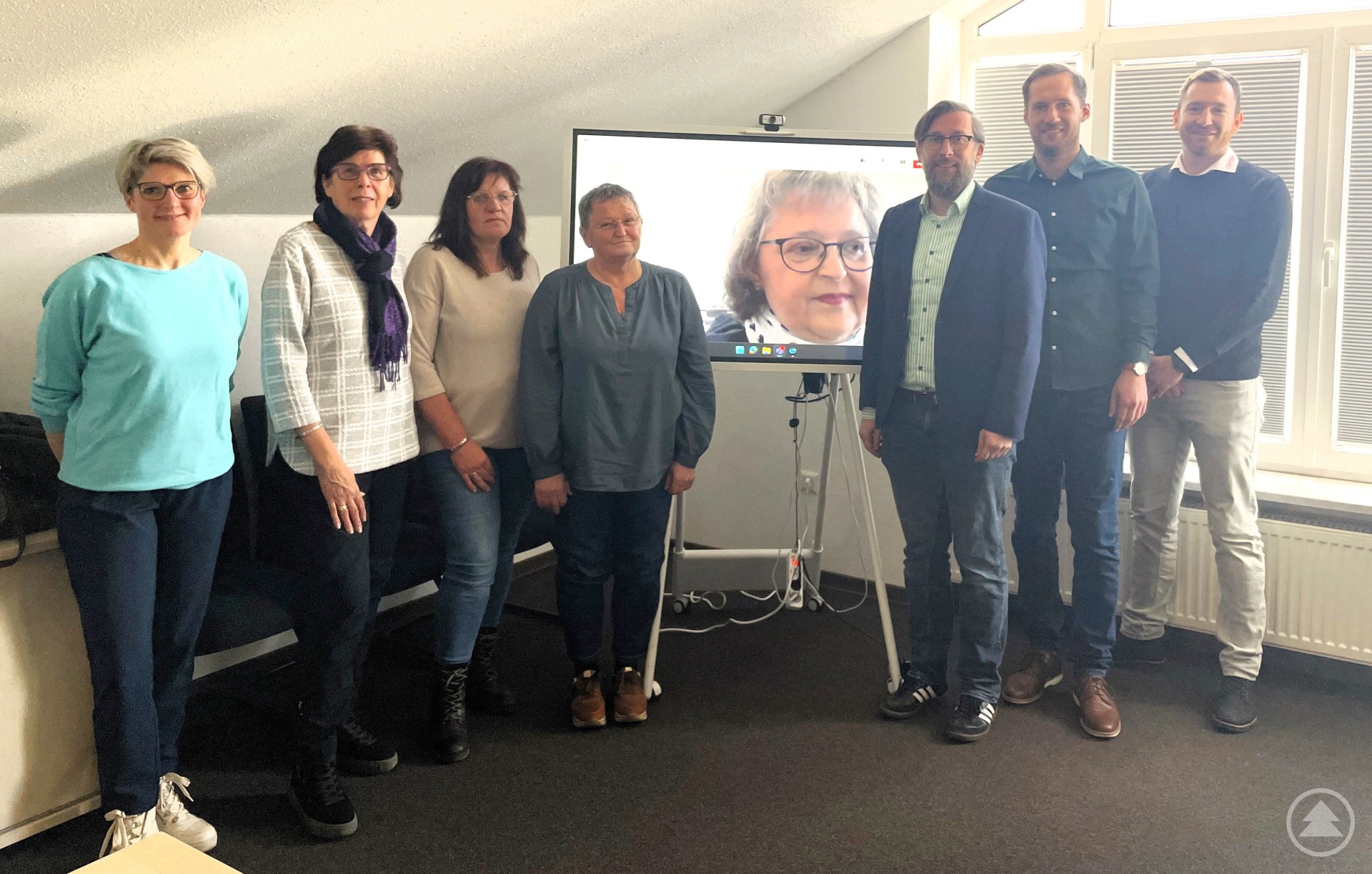 Die Akteure freuen sich über den Projektstart der Selbsthilfegruppen für pflegende Angehörige im Landkreis. v.l. Claudia Geiß (Caritas), Christel Großer, Heidi Töpfl, Renate Kloiber, auf dem Monitor Michaela Kuckis-Schmalzbauer, Christian Fiebig (Landratsamt), René Kurz (Landratsamt) und Florian Kasparak (Vorstand Caritas).