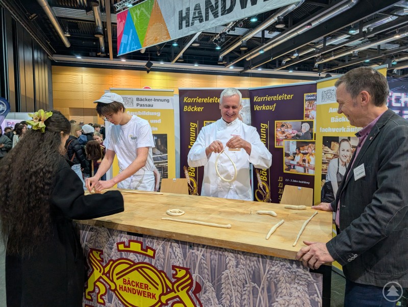 Unterschiedlichste Berufe wurden getestet Bäcker stehen an ihrem Messestand und rollen Teig für ihre Brezeln.