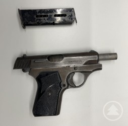 Sichergestellte Schusswaffe bei der Kontrolle auf der BAB 3. Eine sichergestellte Pistole liegt auf einem weißen Untergrund, daneben ist das Magazin separat abgelegt.