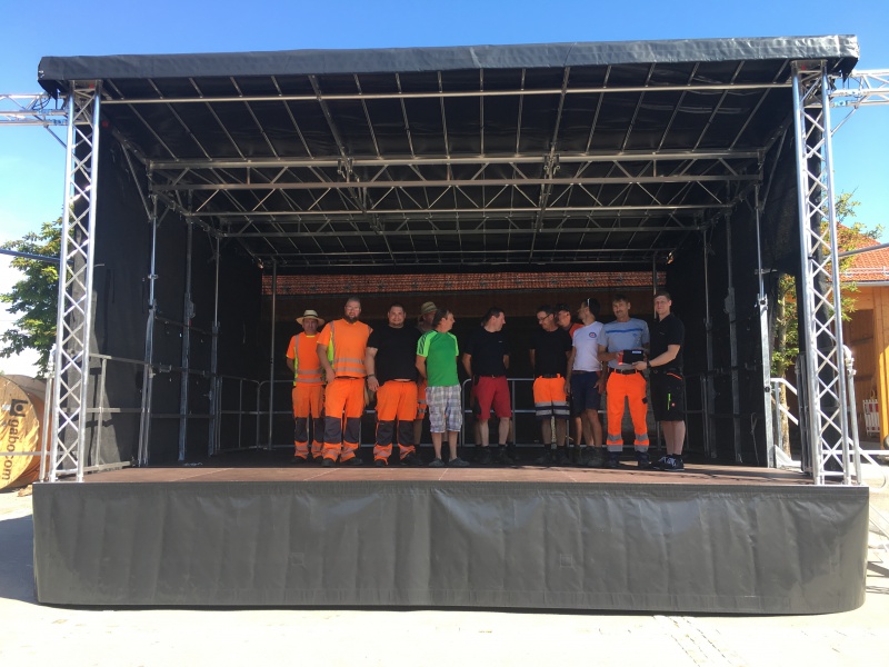 Ein Monteur der Firma „Stagemobil“ zeigte den Bauhofmitarbeitern an einem Dienstagvormitag Ende Juni, wie die Bühne mit ein paar Handgriffen aufgebaut wird. So werden kommunale Ressourcen geschont und das Ehrenamt unterstützt.