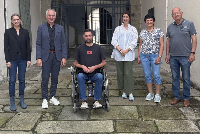 Im Austausch über seniorengerechtes Quartiersmanagement (v. r.): die Kreisbeauftragten Alois Weber, Gertraud Seidl, Nicole Polleichtner und Mario Brandl gemeinsam mit Bürgermeister Stefan Wagner und Quartiersmanagerin Andrea Barth. Sechs Personen, darunter ein Rollstuhlfahrer, stehen auf einem gepflasterten Innenhof vor einem Torbogen. Sie blicken freundlich in die Kamera, es handelt sich um Vertreter:innen aus Politik und Sozialwesen.