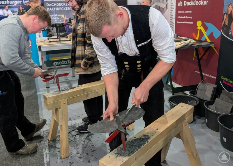 Auszubildender schl&auml;gt eine schwarze Schieferplatte in die Form eines Herzens