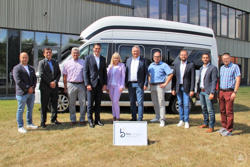 Gemeinsam mit weiteren Beteiligten aus Landkreis, Schulfamilie und Unternehmen freuen sich Landrat Sebastian Gruber (4. v. links), Schulleiterin Elvira Wudy-Engleder (5. v. links) und Geschäftsführer Werner Vaterl (r. daneben) über die neue Fachrichtung „Caravan- und Reisemobiltechnik“ des Ausbildungsberufs „Karosserie- und Fahrzeugbaumechaniker“.