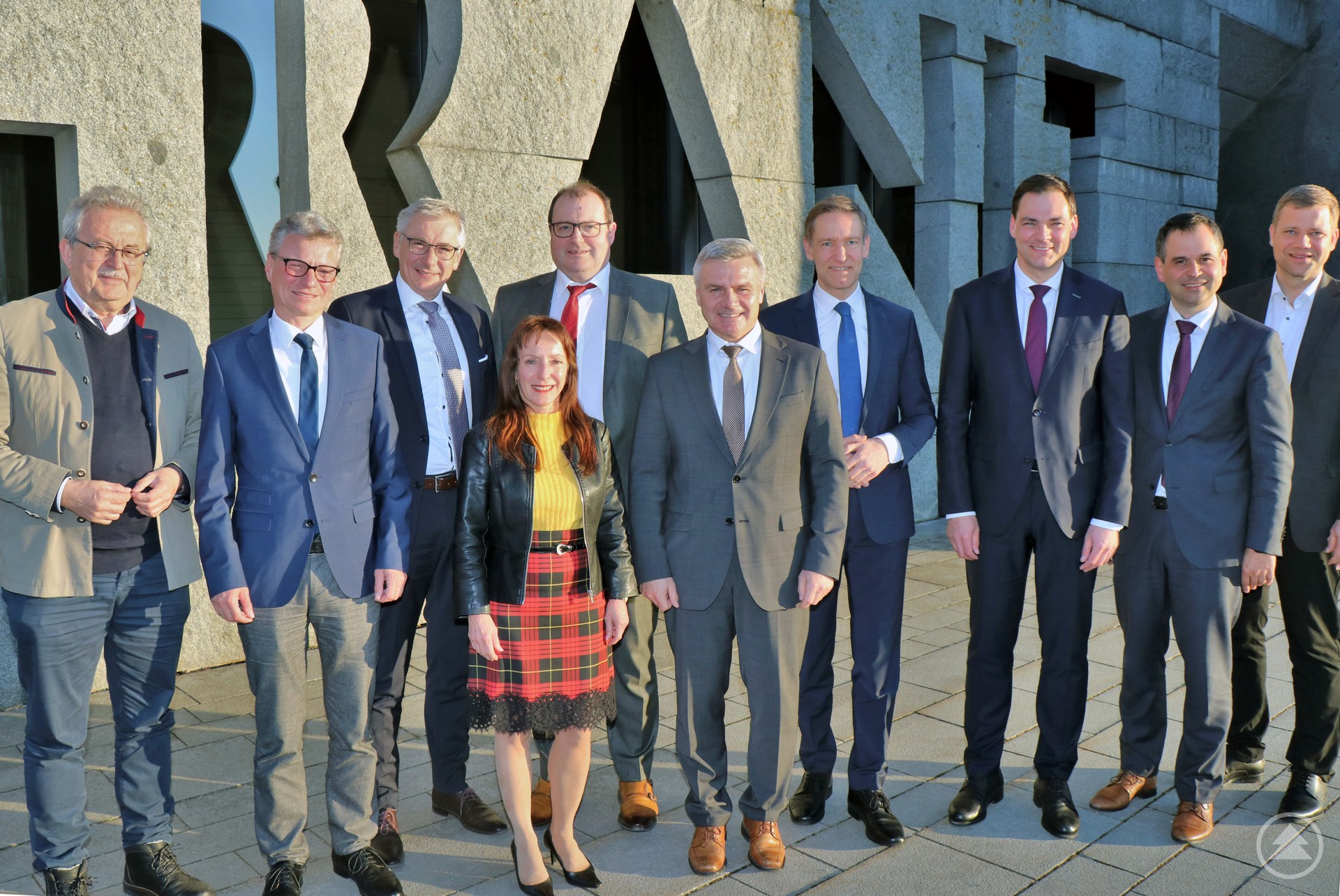 Vor der Front des Granitzentrums Bayerischer Wald in Hauzenberg (v.r.): Bezirkstagspräsident Dr. Olaf Heinrich, Landrat Raimund Kneidinger (Passau), Landräte-Sprecher Sebastian Gruber (Freyung-Grafenau), Regierungspräsident Rainer Haselbeck, Landrat Peter Dreier (Landshut), Landrat Michael Fahmüller (Rottal-Inn), Andrea Degl (Geschäftsführendes Präsidialmitglied des Bayerischen Landkreistages), Landrat Werner Bumeder (Dingolfing-Landau), Landrat Bernd Sibler (Deggendorf) und Landrat Josef Laumer (Straubing-Bogen).