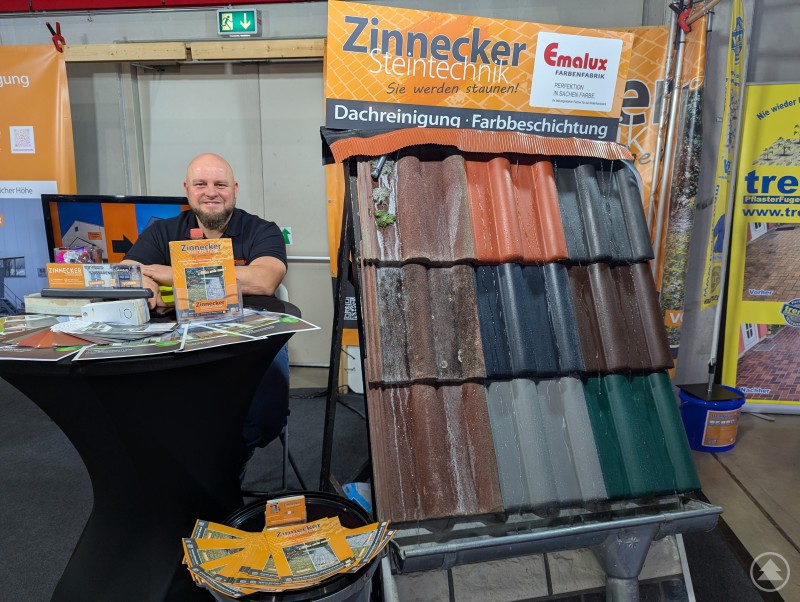 Messestand von Zinnecker Feintechnik mit l&auml;chelndem Mitarbeiter