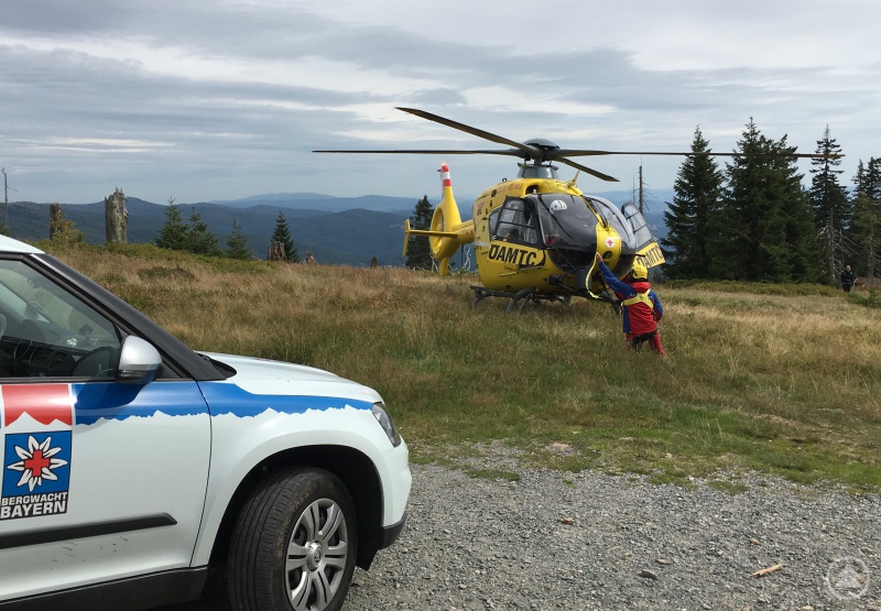 Der Rettungshubschrauber wird von einem Bergretter eingewiesen.