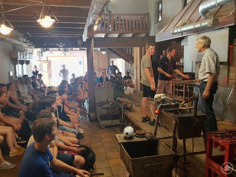 Die Schüler der Mittelschule Viechtach erproben sich in der Glashütte von „Weinfurtner- Das Glasdorf“ unter Anleitung von Richard Weinfurtner. (rechts: Richard Weinfurtner; 2 v. r.: Glasmacher Barthek Cieply)