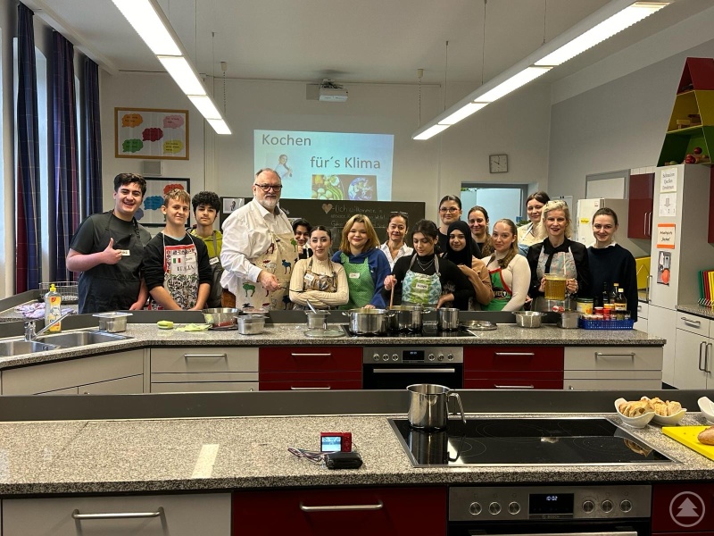 Oberbürgermeister Jürgen Dupper (4. v.l.) und Schulleiterin Andrea Silberhorn (2. v.r.) kochten gemeinsam mit den Fachlehrern, der Schulbegleiterin und den Schülerinnen und Schülern der Mittelschule St. Nikola.