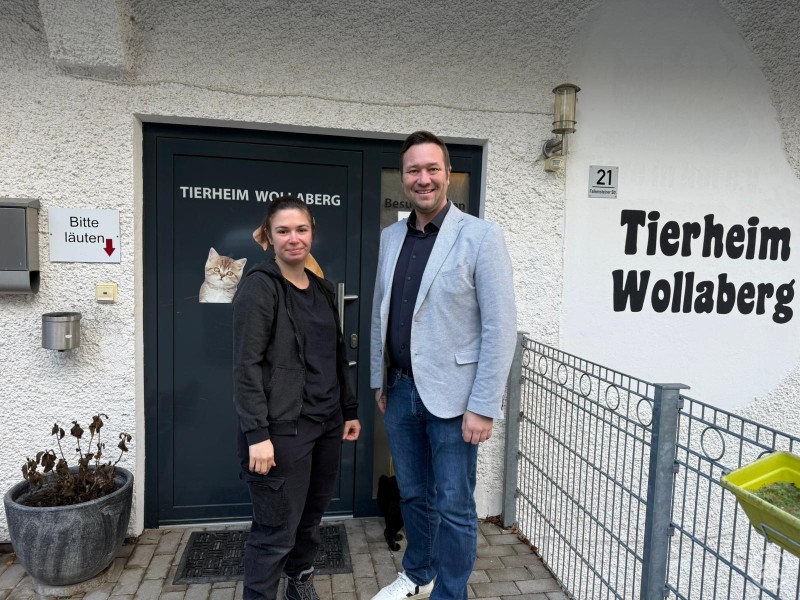 Mitarbeiterin des Tierheims Wollaberg und MdL Josef Heisl Ein Mann und eine Frau stehen vor dem Eingang des Tierheims Wollaberg. Neben der Eingangstür ist der Schriftzug Tierheim Wollaberg zu sehen.