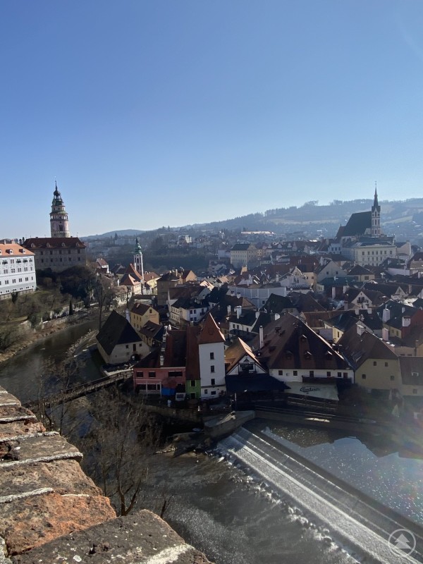 Blick &uuml;ber die Altstadt von Česk&yacute; Krumlov mit roten D&auml;chern, der Moldau und dem markanten Schlossturm im Hintergrund.