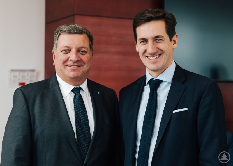 3,6 Mio. Euro Städtebauförderung für die Reaktivierung des „Gistl-Anwesens“: MdL Ebner überbringt die guten Nachrichten für das Projekt in Frauenau und dankt Minister Bernreiter für die Unterstützung. Zwei Männer in dunklen Anzügen stehen in einem Innenraum vor einer Holzverkleidung und einem Bildschirm und blicken in die Kamera.