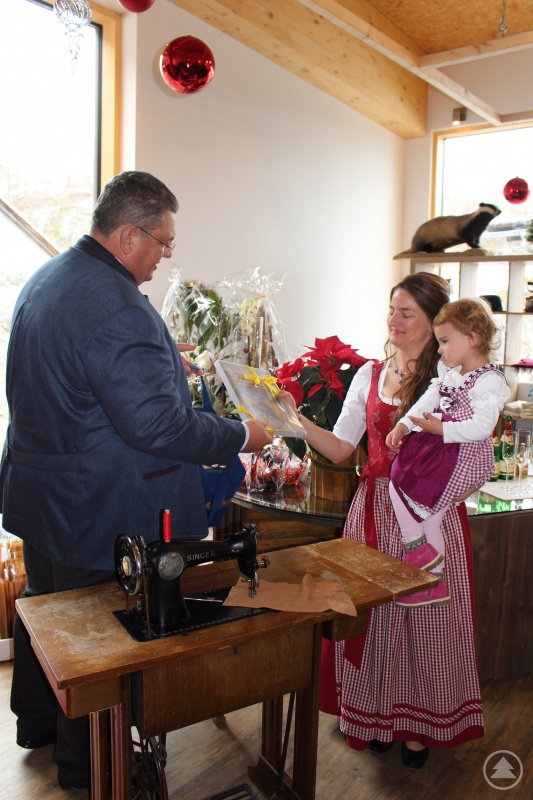 Grafenaus erster Bürgermeister Max Niedermeier überreichte Firmeninhaberin Maria Freund mit Töchterchen Jasmin in ihren Armen das Wappen der Stadt Grafenau.
