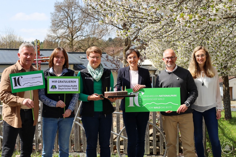 Zum Firmenjubiläum überreicht der Nationalpark Bayerischer Wald eine Geburtstagstorte. (v.l.n.r. 1. Bürgermeister der Mitgliedsgemeinde Neuschönau und stellvertretender Aufsichtsratsvorsitzender der FNBW Alfons Schinabeck, Elke Ohland, Teresa Schreib beide vom Nationalpark Bayerischer Wald sowie Nationalparkleiterin Ursula Schuster und Geschäftsführer der Ferienregion Robert Kürzinger sowie stellvertretende Geschäftsführerin Sabine Lemberger)