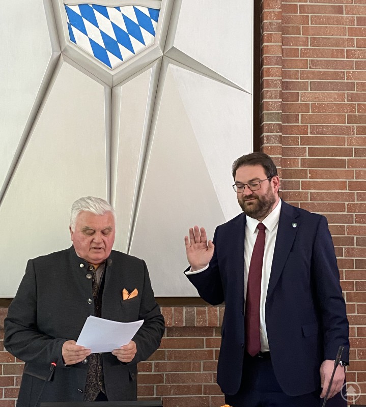 Der neue Landrat Tobias Beck (rechts) wird vom Kreistagsältesten Ludwig Waas vereidigt. Der neue Landrat Tobias Beck legt im Sitzungssaal des Kreistags den Amtseid ab, während das älteste Kreistagsmitglied Ludwig Waas die Vereidigung durchführt.