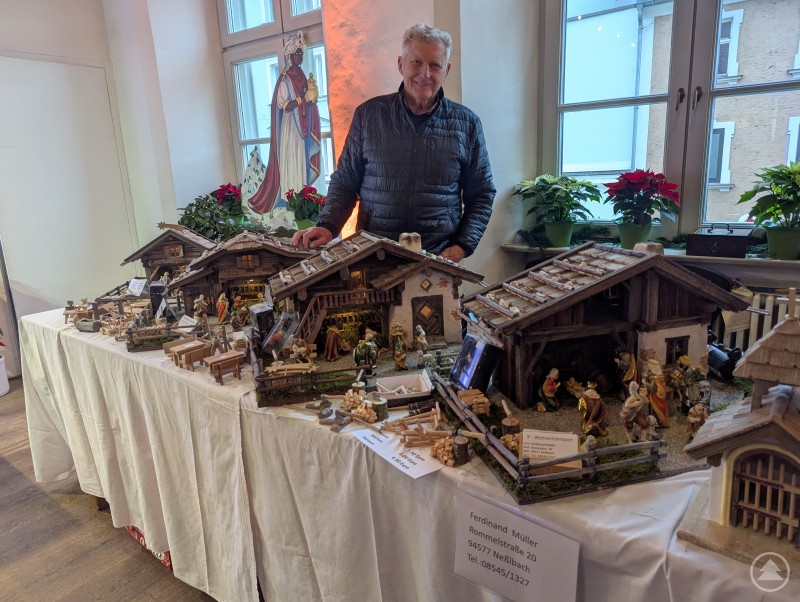 Ferdinand Müller steht hinter seinem Stand mit selbstgebauten Weihnachtskrippen