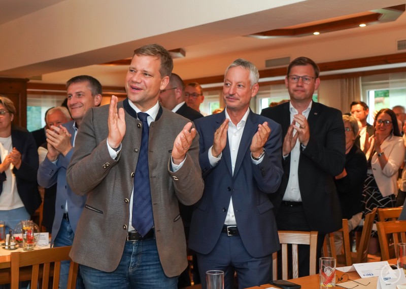 Mehrere CSU-Mitglieder stehen und applaudieren im vollbesetzten Saal der Boxleitenmühle.