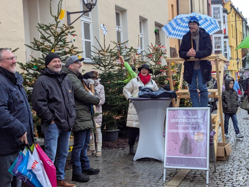 Lachende Menschen bei der Christbaumversteigerung