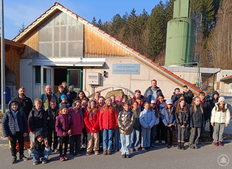Die Klassen 4a und 4b mit v. l. Florian Joachimsthaler, Michael Prager, Ramona Wosnitza und Sebastian Biereder. Gruppenfoto vor der Kläranlage Spiegelau mit den Schülerinnen und Schülern der Klassen 4a und 4b sowie den begleitenden Erwachsenen bei sonnigem Wetter.