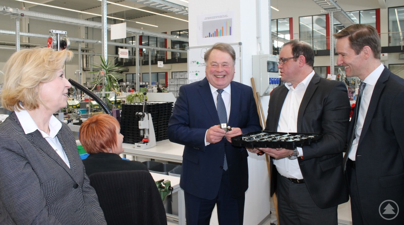 Staatsminister Helmut Brunner (Mi.) und Regierungspräsident Rainer Haselbeck (re.) lassen sich von Gesellschafterin Gabriela Römer (li.), einer Mitarbeiterin und Werksleiter Udo Kronawitter die Produkte von AVS Römer erläutern.