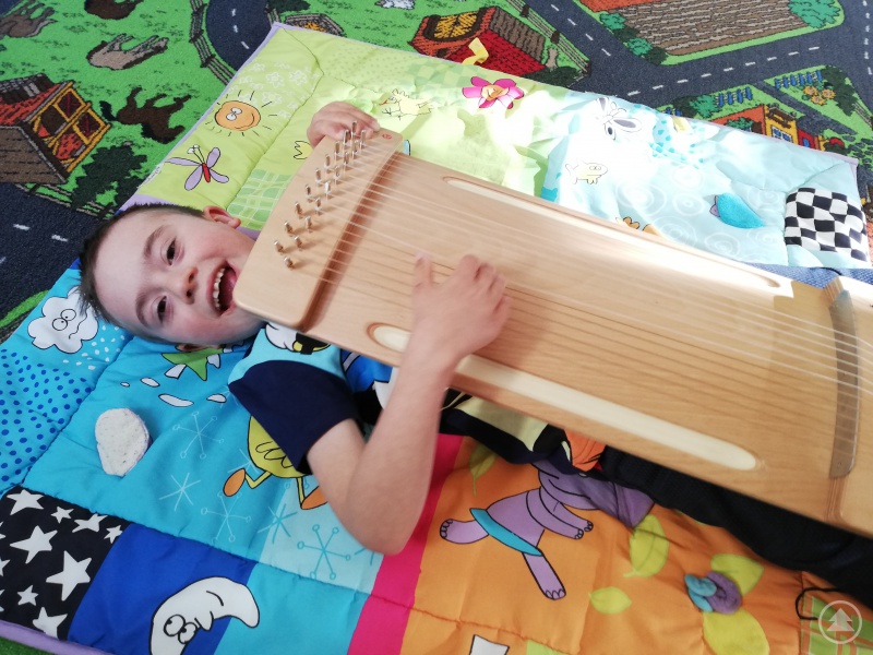 Dieser Junge ist ganz begeistert vom Spür-Monochord, das die Schwingung der Saiten auf den Körper überträgt und so besonders entspannend wirkt.