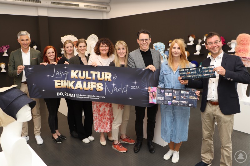 Vorstellung des Programms zur 17. Langen Kultur- und Einkaufsnacht am 22. Mai 2025 Eine Gruppe von Personen hält ein Banner mit der Aufschrift „Lange Kultur- und Einkaufsnacht 2025“ und lächelt in die Kamera.