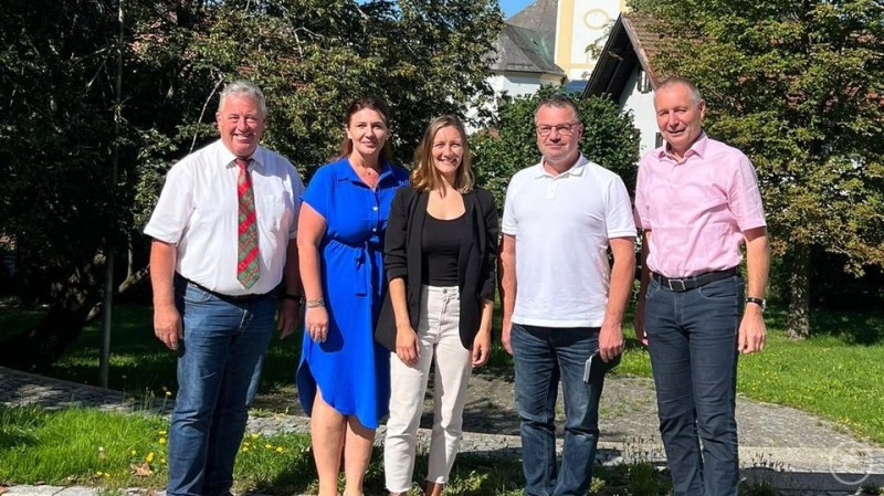 Manuela Topolski (Mitte) mit den Bürgermeistern der ILE Grüner Dreiberg bei der Bekanntgabe der Vertragsverlängerung bis 2027. Fünf Personen stehen nebeneinander im Freien, lächeln in die Kamera und posieren vor Bäumen und Gebäuden bei sonnigem Wetter.