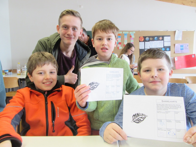 Stolz zeigen die Viertklässler ihr Stempelheft mit den absolvierten Stationen der Schulhausrallye, bei der ihr Tutor Luca sie begleitete.