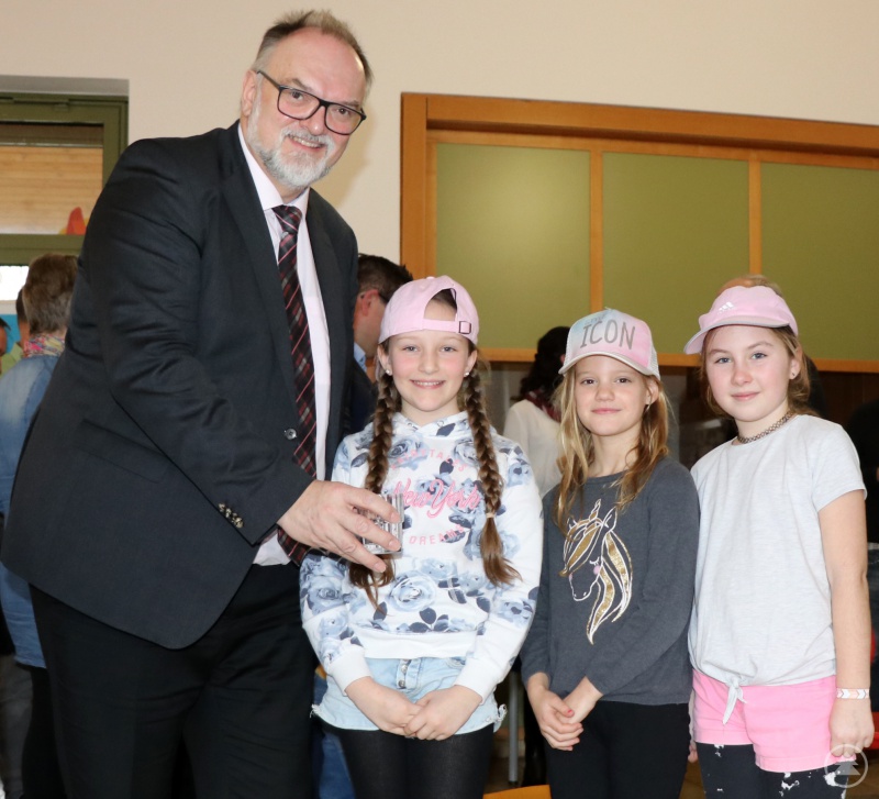 Oberbürgermeister Jürgen Dupper verteilt das Wasser vom neuen Trinkbrunnen an Schülerinnen, die bei der Einweihungsfeier mitgewirkt haben.