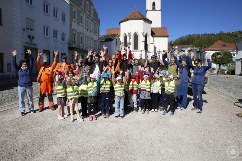 Tanz in den Mai: In jeder Richtung gute Laune. Da mussten alle Beteiligten einfach mit. Kinder, Erwachsene und Bauhofmitarbeiter stehen gemeinsam auf dem Platz und heben die Hände in die Höhe.
