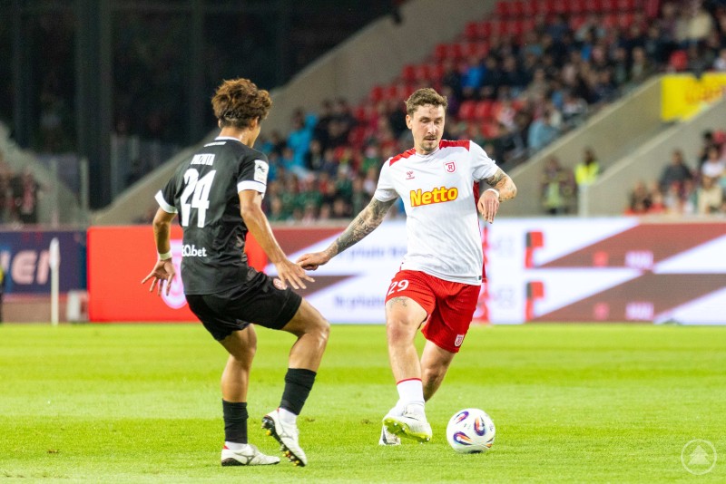 Zwei Spieler im direkten Zweikampf um den Ball, einer vom SSV Jahn im weißen Trikot, einer von Rot-Weiss Essen im schwarzen Trikot.