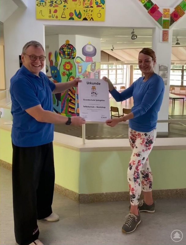 Übergabe der Workshop-Urkunde durch Paul Gruber an Frau Ulrike Rabner 	  		von der Grundschule Spiegelau, unter Einhaltung der Hygieneschutzregeln.	   		Frau Rabner und Herr Gruber sind geimpft, getestet und der Abstand wurde 	  		eingehalten. Die Maske wurde nur für das Bild abgenommen.