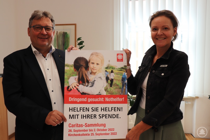 Die Caritasvorstände, Mag.a (FH) Andrea Anderlik, MSc, und Diakon Konrad Niederländer machen mit dem Plakat zur Herbstsammlung deutlich, dass Nothelfer gesucht sind, die sich solidarisch einsetzen.