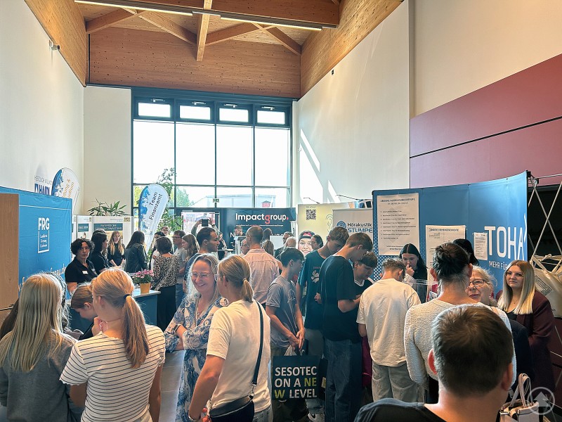 Zahlreiche Besucherinnen und Besucher drängen sich durch die Gänge der Ausbildungs- und Arbeitsbörse im HAIDL-Atrium, während Firmenstände die Halle säumen.