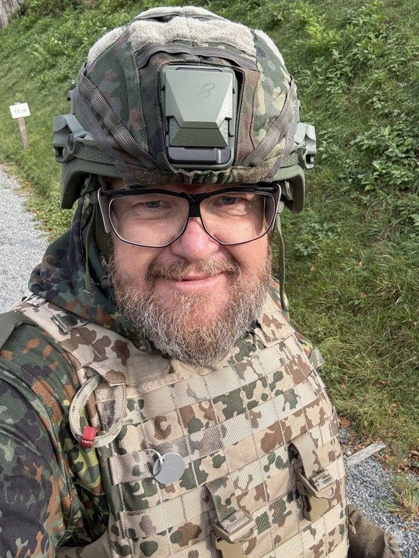 Gerhard Drexler in Gefechtsausrüstung mit Helm und Schutzweste bei einer Übung im Gelände.