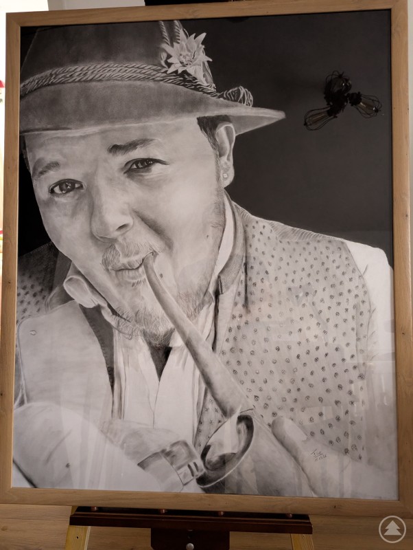 Zu sehen ist ein gro&szlig;formatiges realistisches Portrait des Addnfahrers, das mit Bleistift und Kohle auf dunklem Hintergrund gezeichnet wurde.