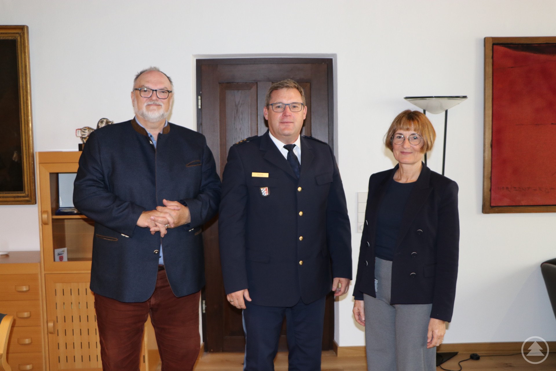 Oberbürgermeister Jürgen Dupper (links) begrüßt gemeinsam mit Ordnungsreferentin Karin Schmeller (rechts) den neuen Passauer Polizeidirektor Christian Dichtl (Mitte) im Rathaus. Drei Personen, zwei Männer und eine Frau, stehen in einem Raum. Der Mann in der Mitte trägt eine Polizeiuniform, die anderen beiden Business-Kleidung.