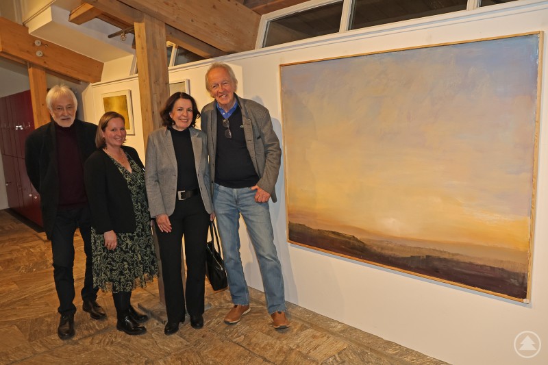 Freuen sich auf viele Kunst-Liebhaber: Josef Loher von rechts mit seiner Frau Rita, Nationalparkmitarbeiterin Nicole Graf Kilger und Laudator Karl Heinz Reimeier. Vier Personen stehen in einer Galerie neben einem großformatigen Landschaftsgemälde und präsentieren eine Kunstausstellung.