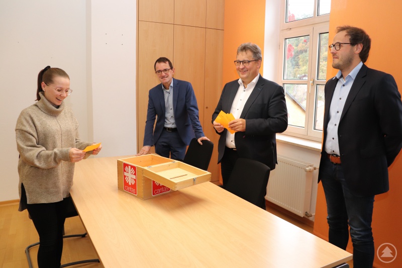 Die Auszubildende Selina Wilhelm zog die Gewinner der Restcent-Aktion. Die Caritas-Vorstände Michael Endres (v. li.) und Diakon Konrad Niederländer und der Fachbereichsleiter Personalabrechnung Patrick Lang freuten sich über die Solidarität der Mitarbeitenden.