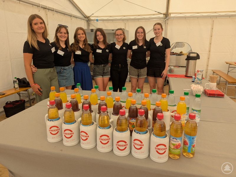 Mitarbeiterinnen der MAX STREICHER GmbH hinter Tresen im überdachten Zelt