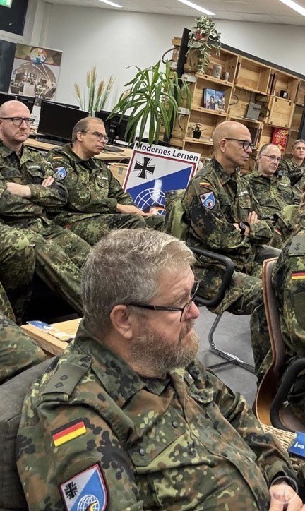 Teilnehmende der Informationswehrübung hören in einem Unterrichtsraum sicherheitspolitischen Vorträgen zu.