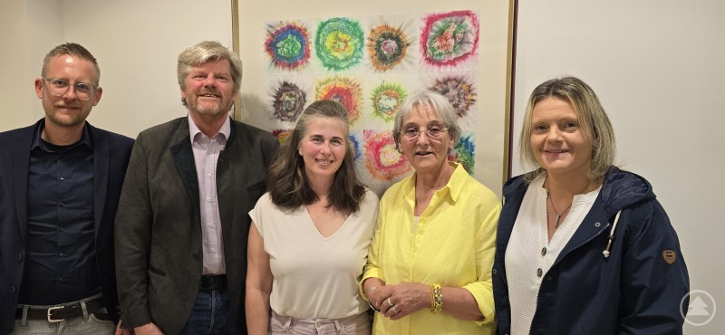 Der Vorstand der AGkE fordert bei seiner Sitzung in Passau mehr Mittel für die katholischen Erziehungshilfen – mit dabei Maik Holstein, Johannes Erbertseder, Erika Paul, Aloisia Rothenwührer und Stephanie Höltl. Fünf Personen stehen in einem hellen Raum vor einem farbenfrohen Kunstwerk. Zwei Männer und drei Frauen posieren freundlich für ein Gruppenfoto.