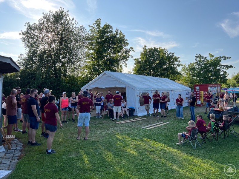 Mann in Vereinskleidung spricht zu einer Gruppe Jugendlicher im Freien