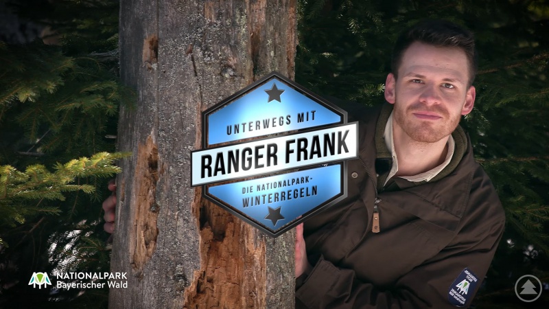 Schelmisch hinterm Baum hervor schaut Kabarettist Martin Frank im Vorschaubild des Nationalpark-YouTube-Kanals.