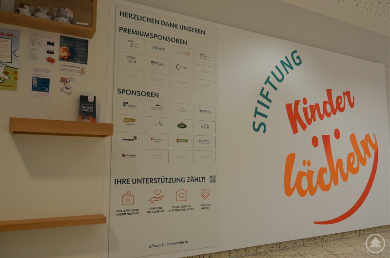 Das Team der Stiftung Kinderlächeln weiht neue Sponsorenwand im Eingangsbereich der Kinderklinik ein.