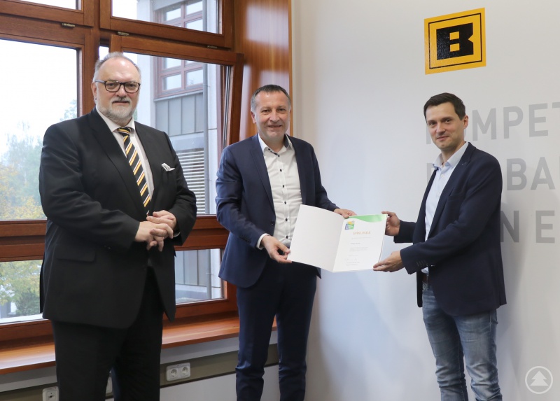 Prokurist Hans Fischer (von rechts) und Vorstand Klaus Höhenberger präsentieren die Urkunde für die Teilnahme am Umwelt- und Klimapakt Bayern, die Oberbürgermeister Jürgen Dupper zuvor überreicht hat.