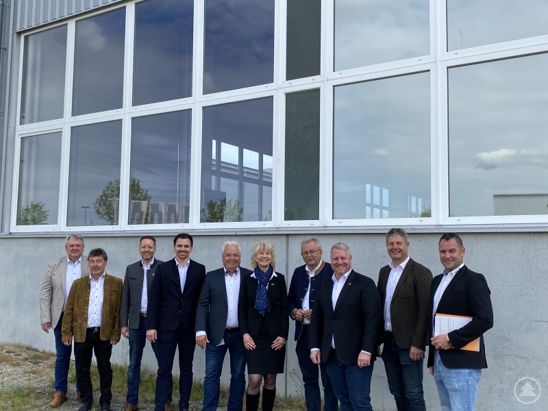 Die Vertreter von Encory und der Sturm Unternehmensgruppe gemeinsam mit den Vertretern aus Politik und Verwaltung vor einem der Gebäude. Eine Gruppe von Vertretern der Encory GmbH, der Sturm Unternehmensgruppe sowie aus Politik und Verwaltung posiert vor einem großen Gebäude mit Glasfassade.