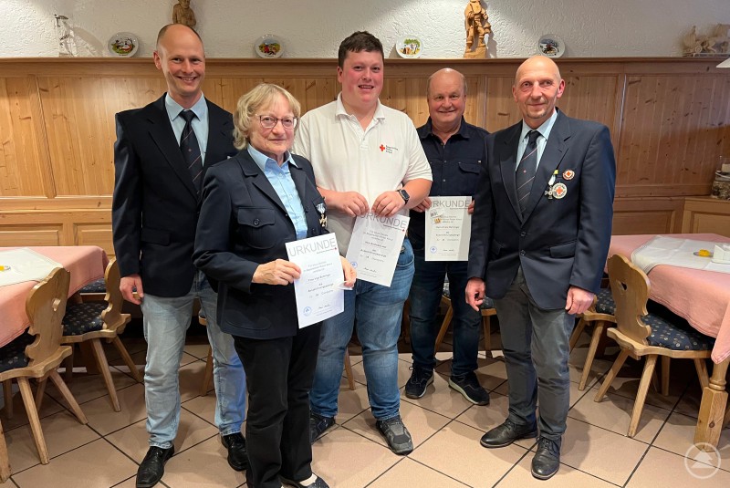 Die geehrten Mitglieder gemeinsam mit den beiden Bereitschaftsleitern Helmut Liebl und Markus Schöller. Drei geehrte Mitglieder mit Urkunden in der Hand stehen zwischen zwei Bereitschaftsleitern in Uniform, im Hintergrund rustikale Holzvertäfelung.